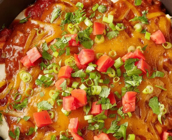 Hearty cheesy casserole topped with tomatoes and cilantro in a vibrant presentation.