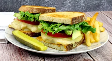 Savory sandwiches with chicken, cheese, avocado, and crispy fries for a delicious meal.