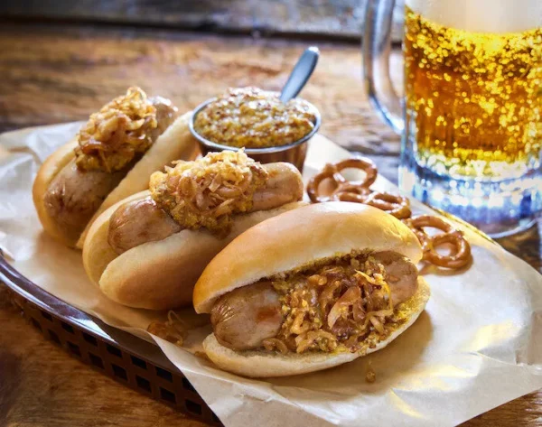 Savory mini bratwurst sandwiches topped with onions and mustard, perfect for casual gatherings.
