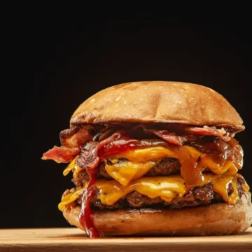 Indulgent towering burger with beef patties, melted cheese, crispy bacon, and rich sauces.